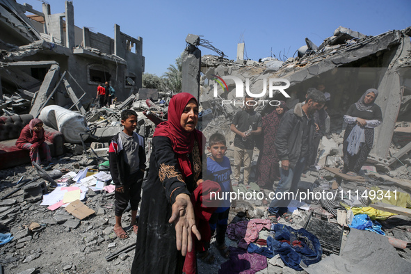 Palestinians are inspecting the damage to a building following Israeli bombardment in the Maghazi camp for Palestinian refugees in the centr...