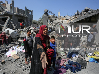 Palestinians are inspecting the damage to a building following Israeli bombardment in the Maghazi camp for Palestinian refugees in the centr...