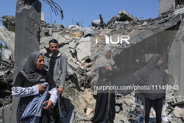 Palestinians are inspecting the damage to a building following Israeli bombardment in the Maghazi camp for Palestinian refugees in the centr...