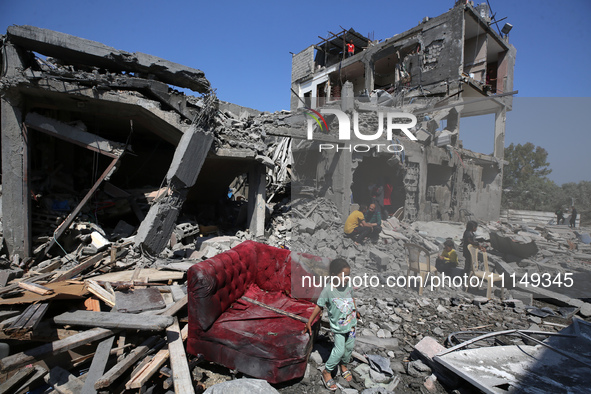 Palestinians are inspecting the damage to a building following Israeli bombardment in the Maghazi camp for Palestinian refugees in the centr...