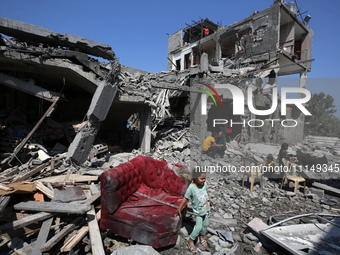 Palestinians are inspecting the damage to a building following Israeli bombardment in the Maghazi camp for Palestinian refugees in the centr...