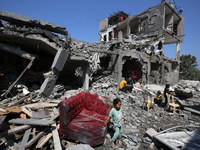 Palestinians are inspecting the damage to a building following Israeli bombardment in the Maghazi camp for Palestinian refugees in the centr...