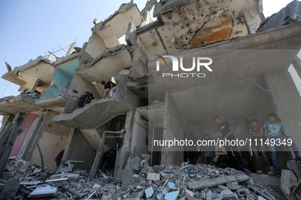 Palestinians are inspecting the damage to a building following Israeli bombardment in the Maghazi camp for Palestinian refugees in the centr...