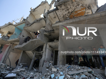 Palestinians are inspecting the damage to a building following Israeli bombardment in the Maghazi camp for Palestinian refugees in the centr...