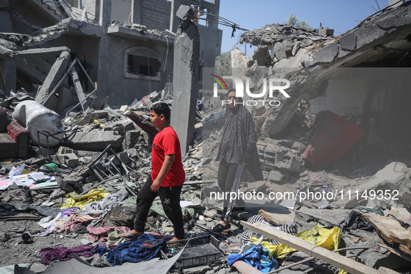 Palestinians are inspecting the damage to a building following Israeli bombardment in the Maghazi camp for Palestinian refugees in the centr...