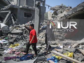 Palestinians are inspecting the damage to a building following Israeli bombardment in the Maghazi camp for Palestinian refugees in the centr...