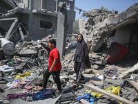 Palestinians are inspecting the damage to a building following Israeli bombardment in the Maghazi camp for Palestinian refugees in the centr...