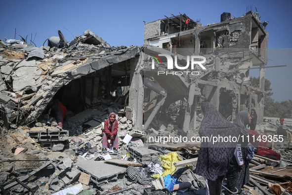 Palestinians are inspecting the damage to a building following Israeli bombardment in the Maghazi camp for Palestinian refugees in the centr...