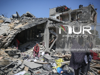 Palestinians are inspecting the damage to a building following Israeli bombardment in the Maghazi camp for Palestinian refugees in the centr...