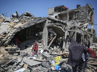 Palestinians are inspecting the damage to a building following Israeli bombardment in the Maghazi camp for Palestinian refugees in the centr...