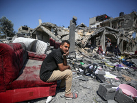 Palestinians are inspecting the damage to a building following Israeli bombardment in the Maghazi camp for Palestinian refugees in the centr...