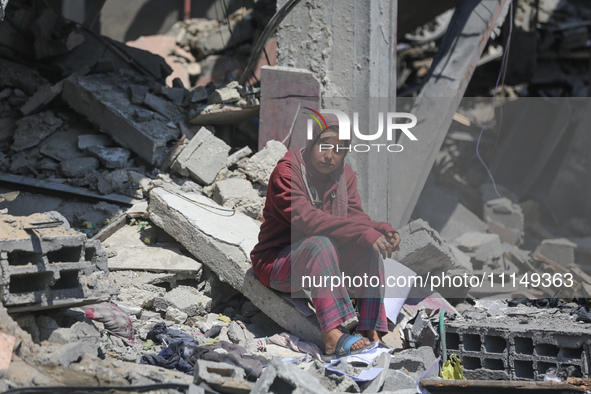 Palestinians are inspecting the damage to a building following Israeli bombardment in the Maghazi camp for Palestinian refugees in the centr...