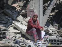 Palestinians are inspecting the damage to a building following Israeli bombardment in the Maghazi camp for Palestinian refugees in the centr...