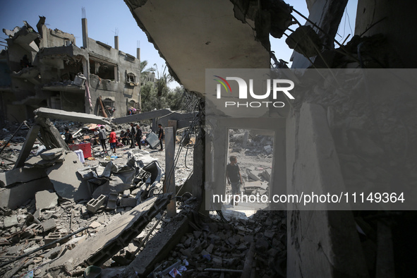 Palestinians are inspecting the damage to a building following Israeli bombardment in the Maghazi camp for Palestinian refugees in the centr...