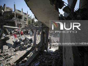 Palestinians are inspecting the damage to a building following Israeli bombardment in the Maghazi camp for Palestinian refugees in the centr...