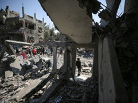 Palestinians are inspecting the damage to a building following Israeli bombardment in the Maghazi camp for Palestinian refugees in the centr...