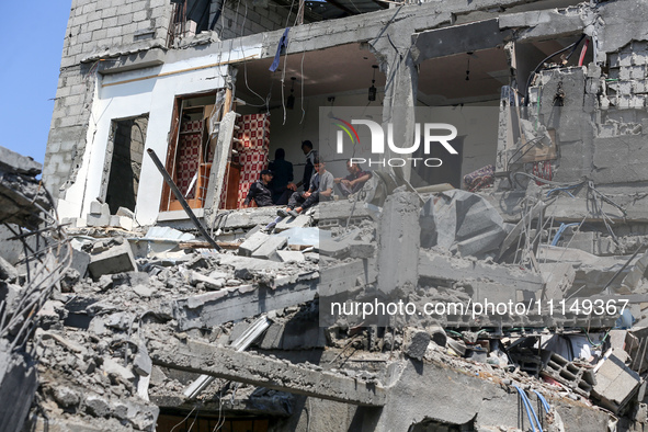 Palestinians are inspecting the damage to a building following Israeli bombardment in the Maghazi camp for Palestinian refugees in the centr...