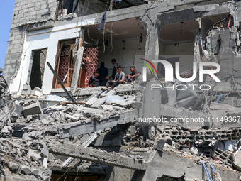 Palestinians are inspecting the damage to a building following Israeli bombardment in the Maghazi camp for Palestinian refugees in the centr...