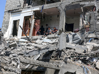 Palestinians are inspecting the damage to a building following Israeli bombardment in the Maghazi camp for Palestinian refugees in the centr...