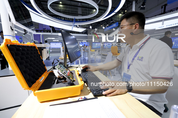 A staff member is demonstrating a computer experiment at the 61st China Higher Education Expo in Fuzhou, Fujian Province, China, on April 15...