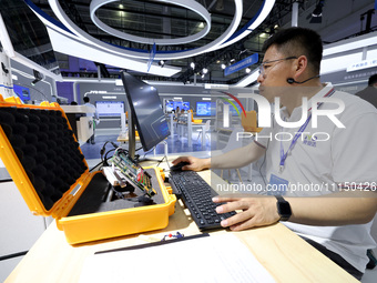 A staff member is demonstrating a computer experiment at the 61st China Higher Education Expo in Fuzhou, Fujian Province, China, on April 15...