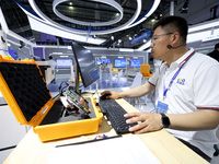 A staff member is demonstrating a computer experiment at the 61st China Higher Education Expo in Fuzhou, Fujian Province, China, on April 15...