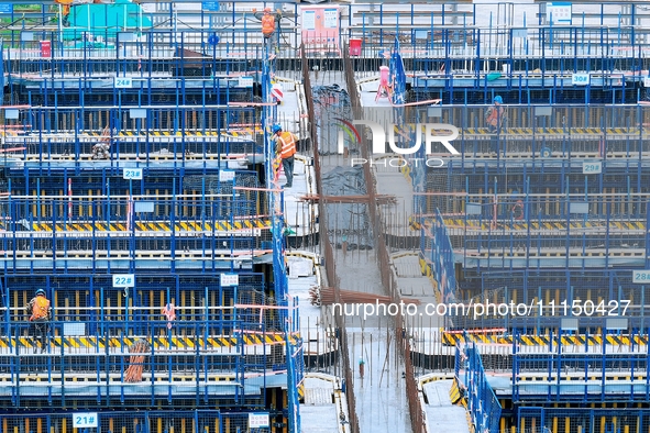 Construction workers are working at the construction site of the Zhangjinggao Yangtze River Bridge in Rugao, Jiangsu Province, China, on Apr...