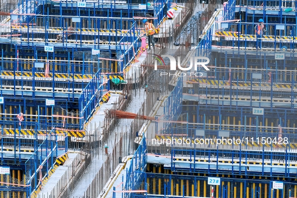 Construction workers are working at the construction site of the Zhangjinggao Yangtze River Bridge in Rugao, Jiangsu Province, China, on Apr...