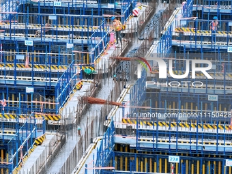 Construction workers are working at the construction site of the Zhangjinggao Yangtze River Bridge in Rugao, Jiangsu Province, China, on Apr...