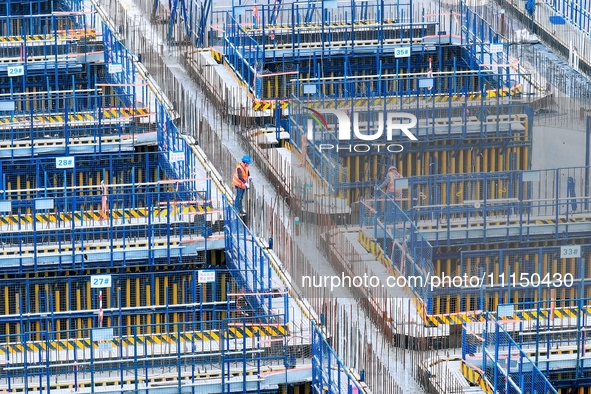 Construction workers are working at the construction site of the Zhangjinggao Yangtze River Bridge in Rugao, Jiangsu Province, China, on Apr...