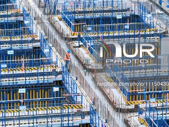 Construction workers are working at the construction site of the Zhangjinggao Yangtze River Bridge in Rugao, Jiangsu Province, China, on Apr...