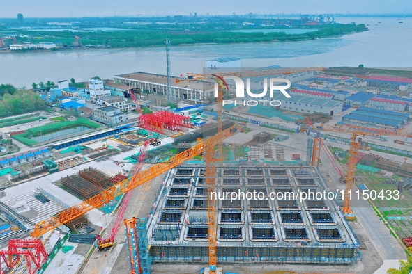 Construction workers are working at the construction site of the Zhangjinggao Yangtze River Bridge in Rugao, Jiangsu Province, China, on Apr...