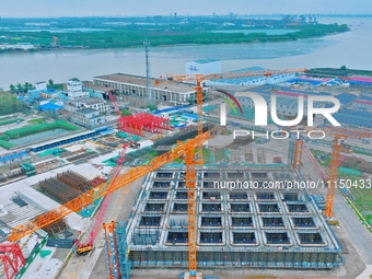 Construction workers are working at the construction site of the Zhangjinggao Yangtze River Bridge in Rugao, Jiangsu Province, China, on Apr...