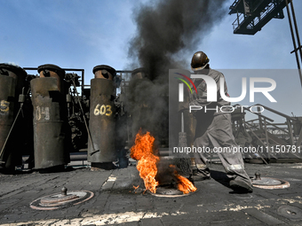 A worker is sweeping on the premises of PJSC Zaporizhcoke in Zaporizhzhia, southeastern Ukraine, on April 11, 2024. NO USE RUSSIA. NO USE BE...