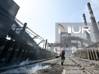 A worker is sweeping on the premises of PJSC Zaporizhcoke in Zaporizhzhia, southeastern Ukraine, on April 11, 2024. NO USE RUSSIA. NO USE BE...