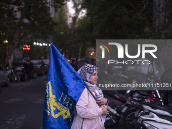 An Iranian woman is carrying a flag of the Islamic Revolutionary Guard Corps while attending a gathering to celebrate the IRGC UAV and missi...