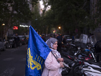 An Iranian woman is carrying a flag of the Islamic Revolutionary Guard Corps while attending a gathering to celebrate the IRGC UAV and missi...