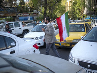 A man is carrying an Iranian flag during a gathering to celebrate the IRGC UAV and missile attack against Israel, in Tehran, Iran, on April...