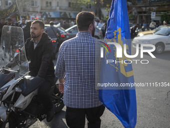 An Iranian man is carrying a flag of the Islamic Revolutionary Guard Corps during a gathering to celebrate the IRGC UAV and missile attack a...