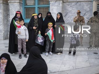 An armed member of the Islamic Revolutionary Guard Corps (IRGC) is speaking on a walkie-talkie and monitoring an area during a celebration o...