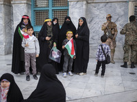 An armed member of the Islamic Revolutionary Guard Corps (IRGC) is speaking on a walkie-talkie and monitoring an area during a celebration o...