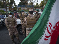 Members of the Islamic Revolutionary Guard Corps (IRGC) Special Forces are standing together behind an Iranian flag during a celebration of...