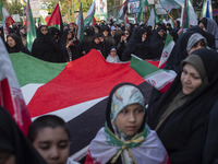 Veiled Iranian women are standing around a huge Palestinian flag during a gathering to celebrate the IRGC UAV and missile attack against Isr...