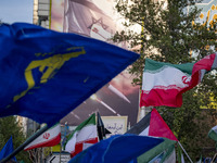 Veiled Iranian women are waving Iranian flags and Islamic Revolutionary Guard Corps flags under an anti-Israeli mural as they gather to cele...