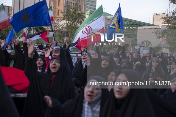 Veiled Iranian women are waving Iranian flags and those of the Islamic Revolutionary Guard Corps as they celebrate the IRGC's UAV and missil...