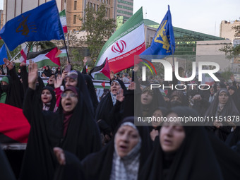 Veiled Iranian women are waving Iranian flags and those of the Islamic Revolutionary Guard Corps as they celebrate the IRGC's UAV and missil...