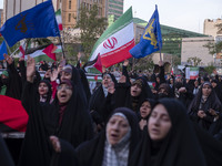 Veiled Iranian women are waving Iranian flags and those of the Islamic Revolutionary Guard Corps as they celebrate the IRGC's UAV and missil...