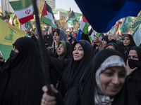 Veiled women are waving Iranian and Palestinian flags during a gathering to celebrate the IRGC UAV and missile attack against Israel, in Teh...