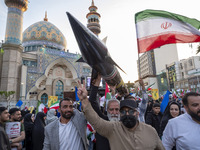 Unidentified men are carrying a model of Iran's first-ever hypersonic missile, Fattah, past a mosque during a gathering to celebrate the IRG...