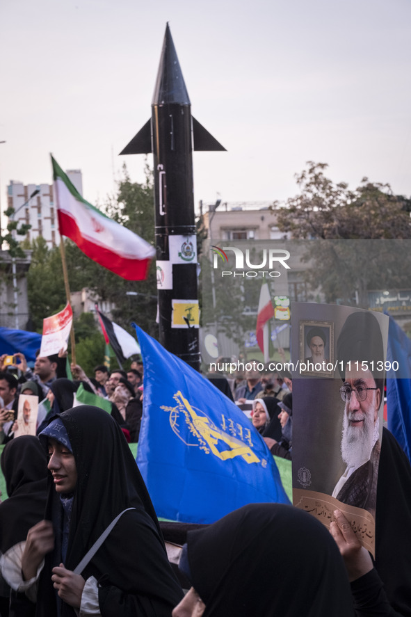 Veiled women are waving the flag of the Islamic Revolutionary Guard Corps and holding a portrait of Iran's Supreme Leader, Ayatollah Ali Kha...